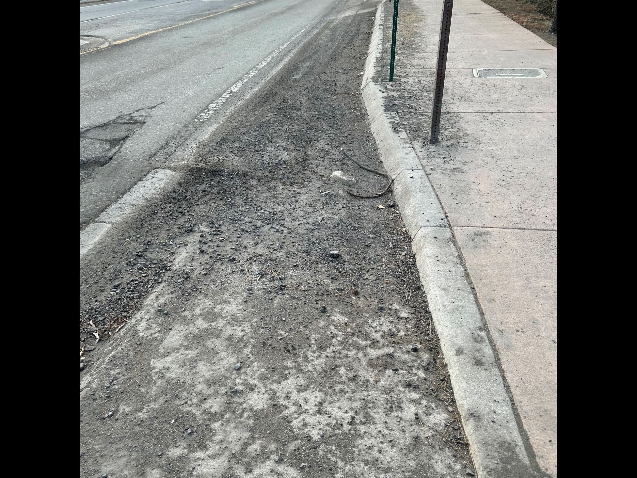 An image of a roadside filled with rocks and gravel.