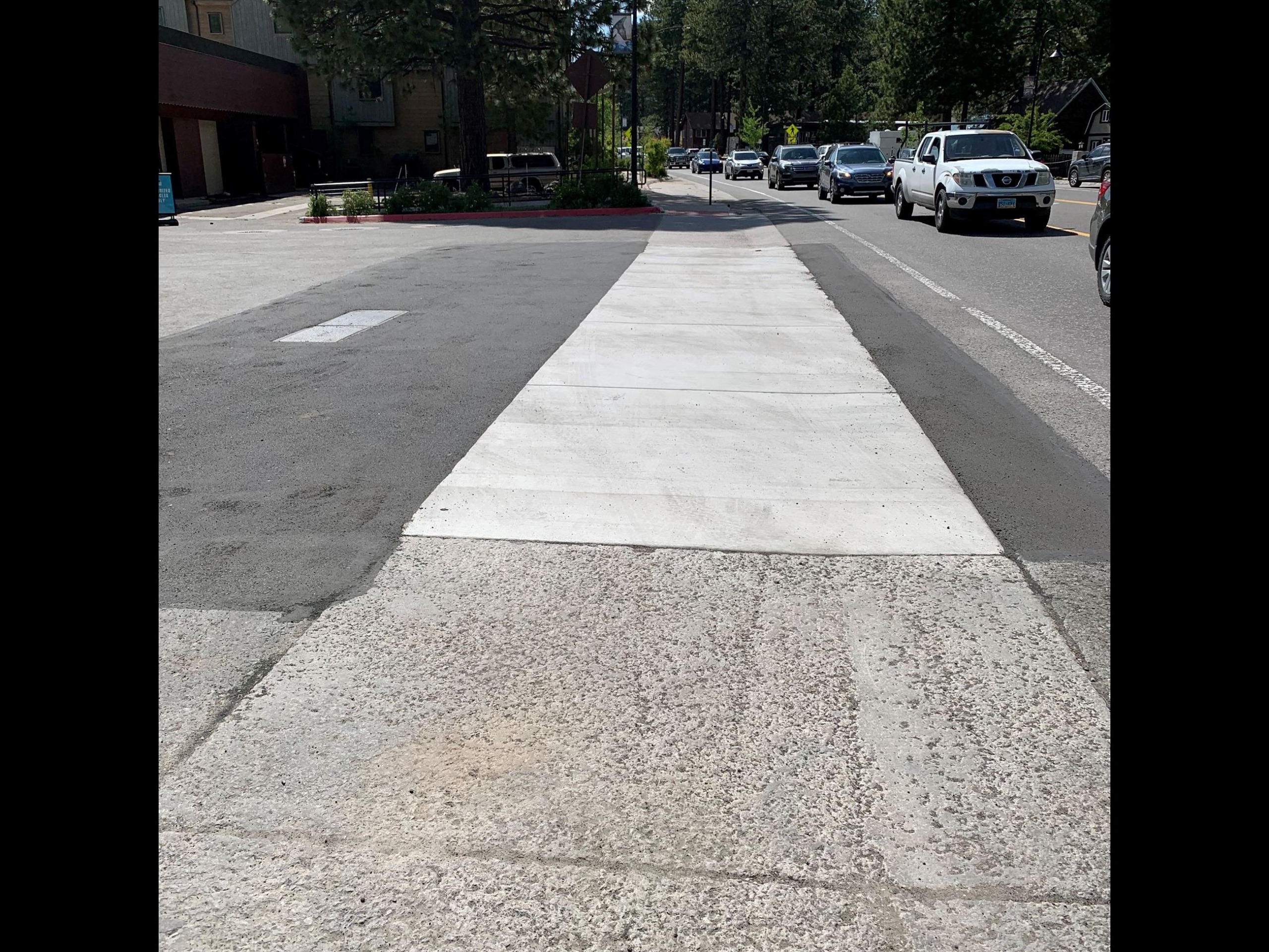 A look at new concrete and previously paved sidewalks near dark asphalt. 